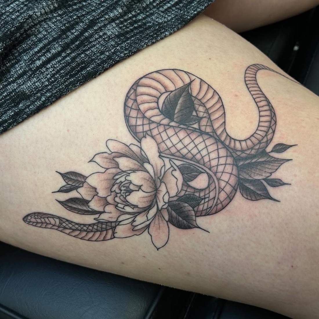Fine-line snake and peony tattoo