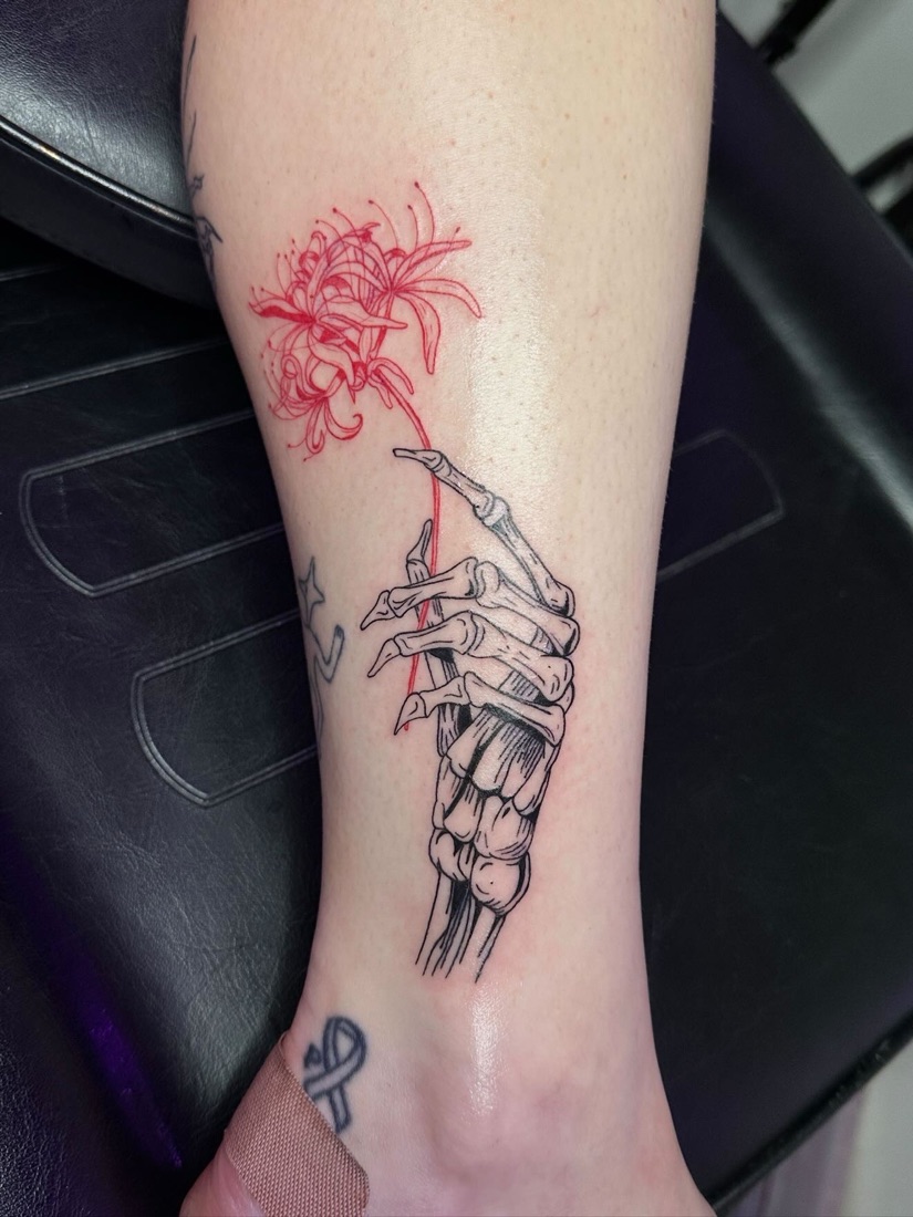 Skeletal hand and florals tattoo